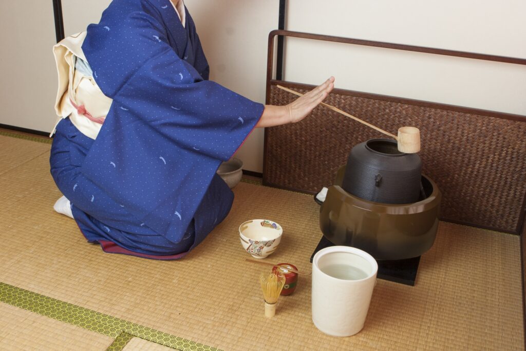 着物姿の女性が和室で風炉を扱っている様子。茶道具としての風炉の査定や買取をイメージさせる落ち着いた雰囲気の写真。