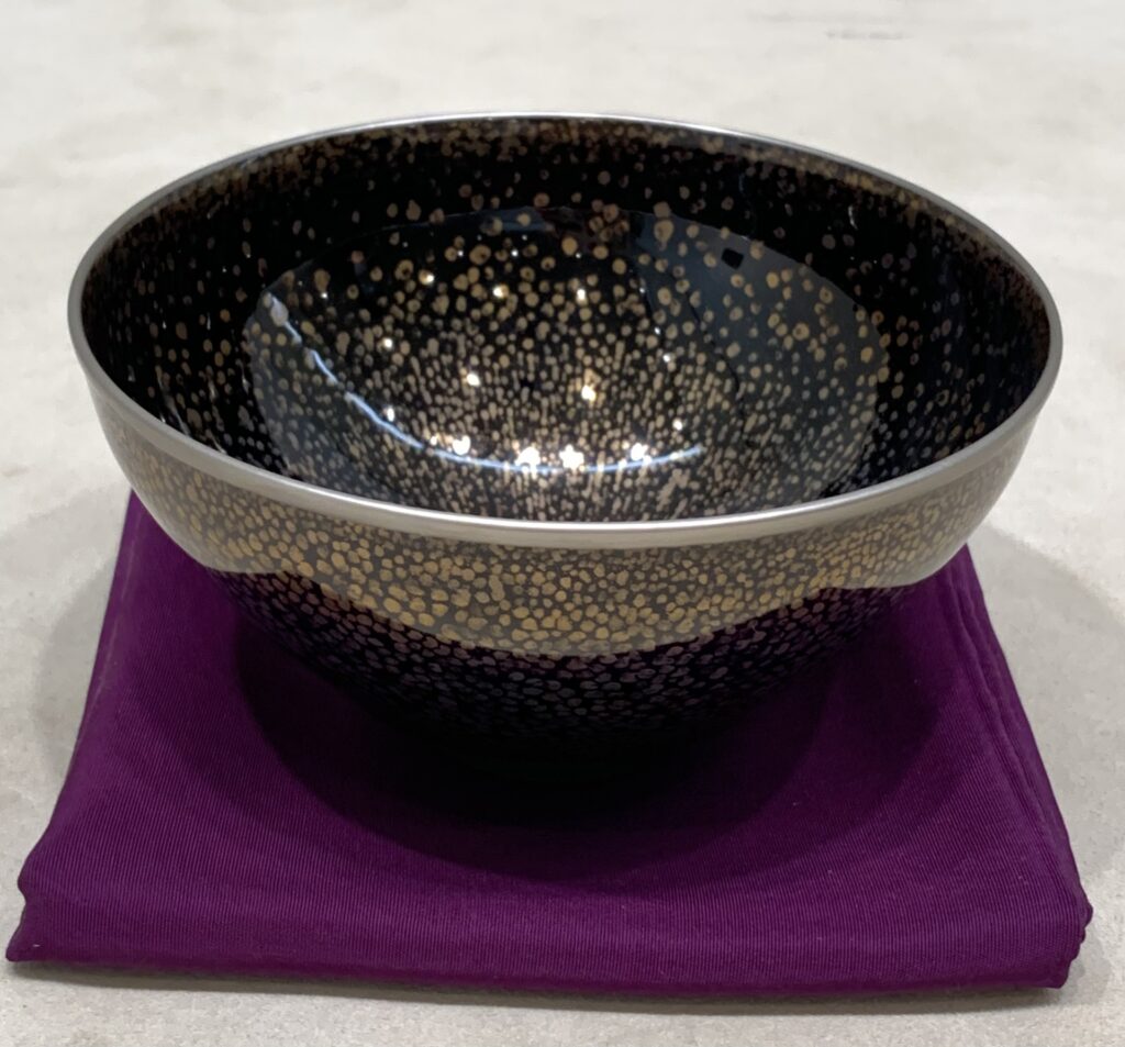 曜変天目茶碗をイメージした器。黒地に星のような斑紋が浮かび、幻の名品と呼ばれる曜変天目の特徴を示す。模倣品も多いため、真贋鑑定や保存状態が高額買取の鍵となることを解説する