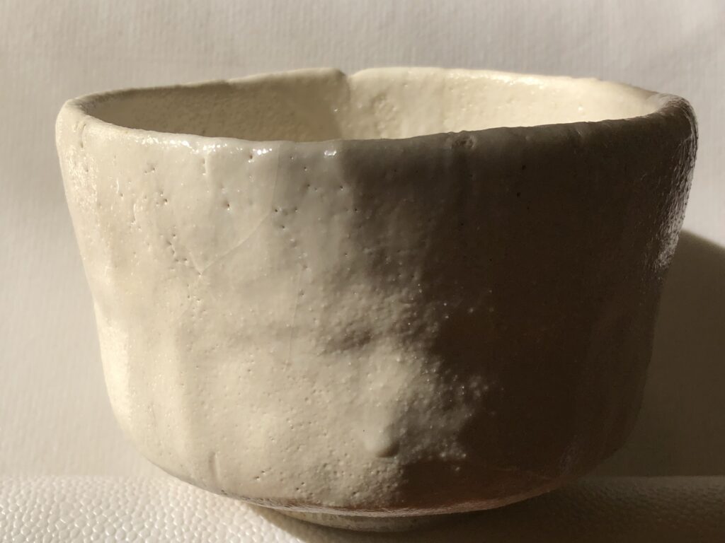 志野焼を思わせる白釉の茶碗。加藤孝造など美濃焼の陶芸家が受け継いだ伝統技法をイメージした写真。