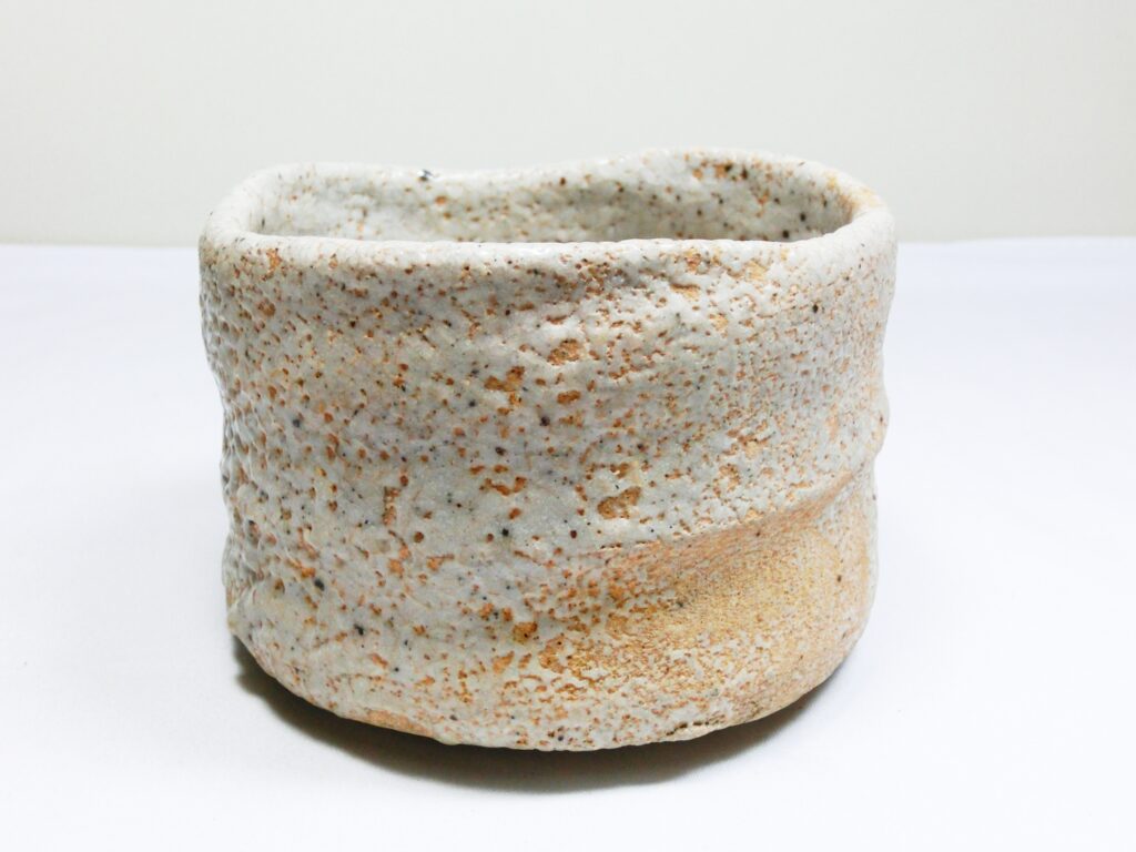 志野焼の茶碗。白い釉薬と土の風合いが調和した、荒川豊蔵作品を想起させる陶器。
